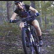 Cyclist wearing Moxie Tee Jersey in forest trail.